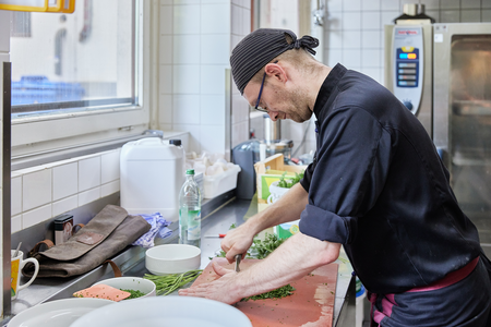 Koch beim Gemüseschneiden